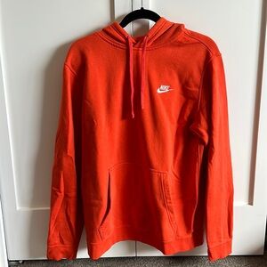 Bright orange Nike sweatshirt.